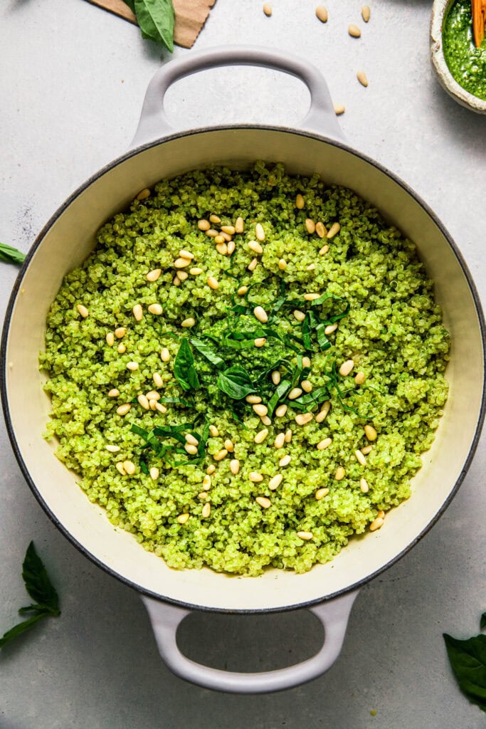 Finished pot of pesto quinoa topped with basil leaves and pinenuts.