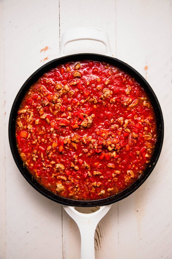 Tomatoes added to skillet with ground turkey.