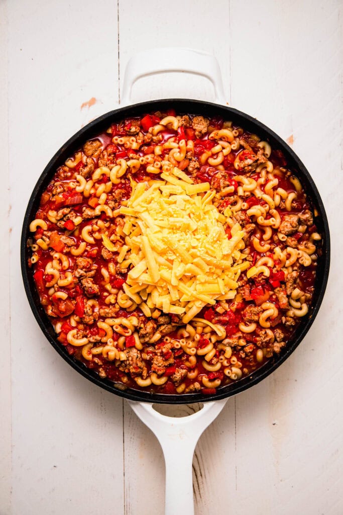 Cheddar cheese added to skillet with elbow mac and ground turkey.