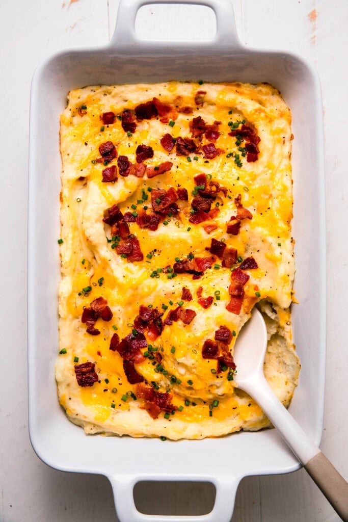 Fully loaded twice baked mashed potatoes in casserole dish ready to serve.