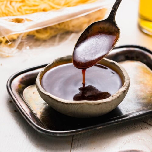 Yakisoba sauce drizzling off of spoon.