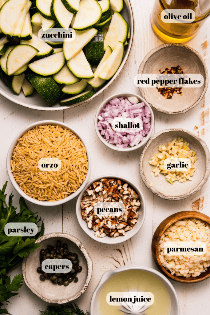 Ingredients for zucchini orzo salad labeled on counter.